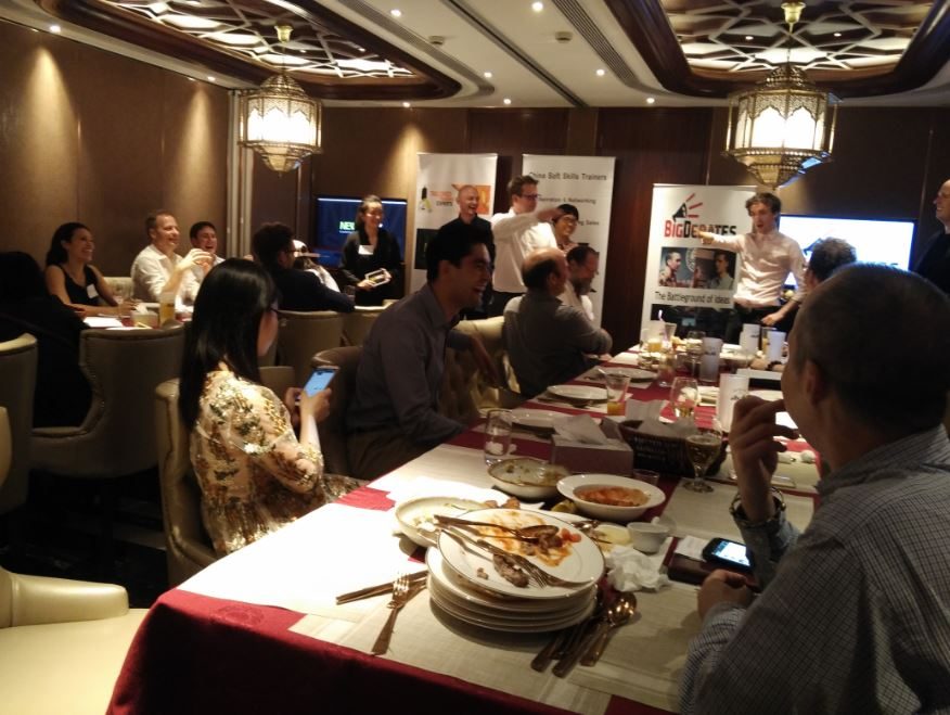 Participants talking together around tables at a presentation-skills event