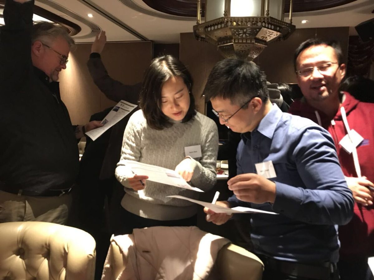 Participants discussing an activity sheet together at an icebreaker event